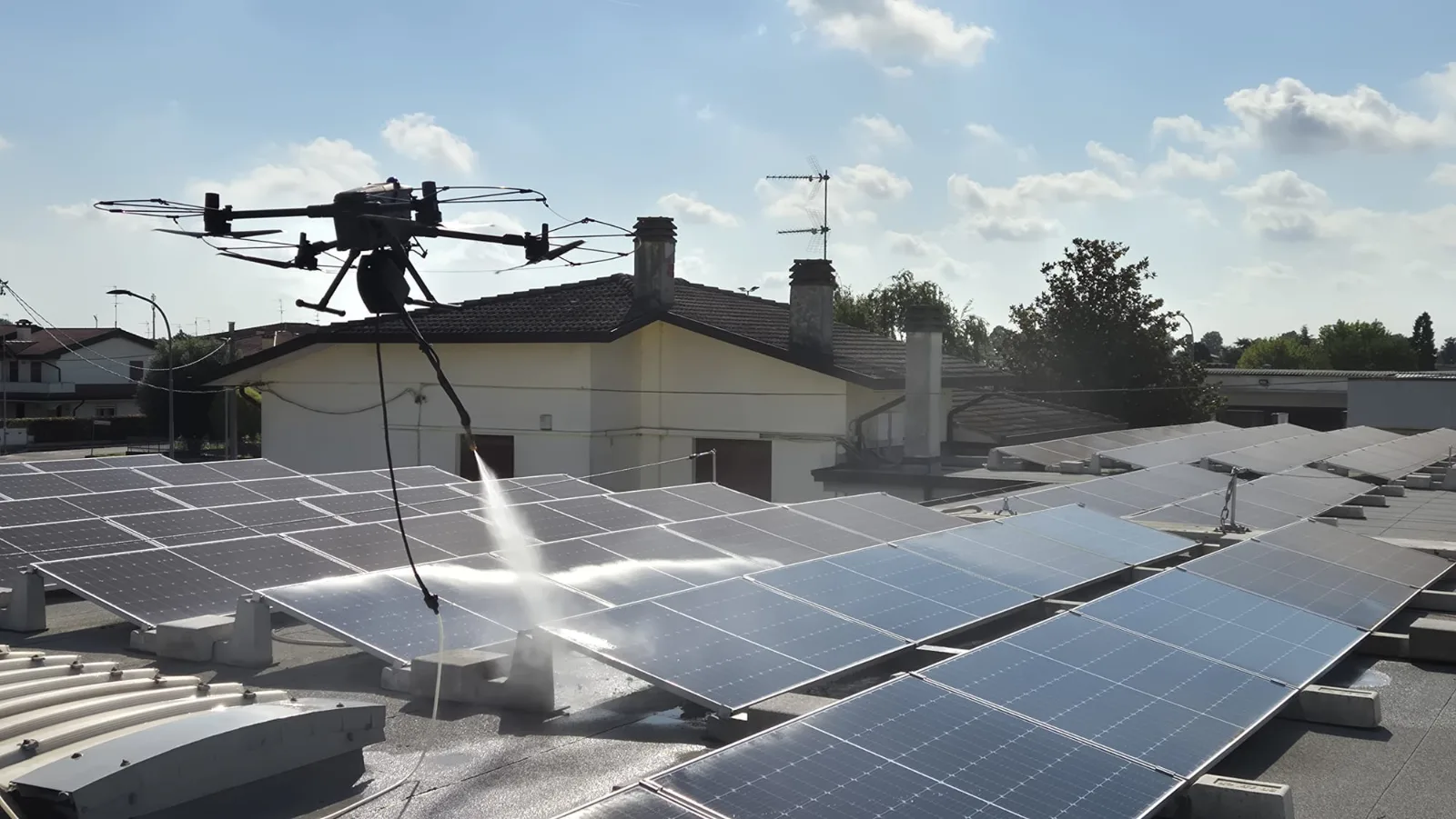 Drone professionale durante il lavaggio dei pannelli fotovoltaici su tetto industriale